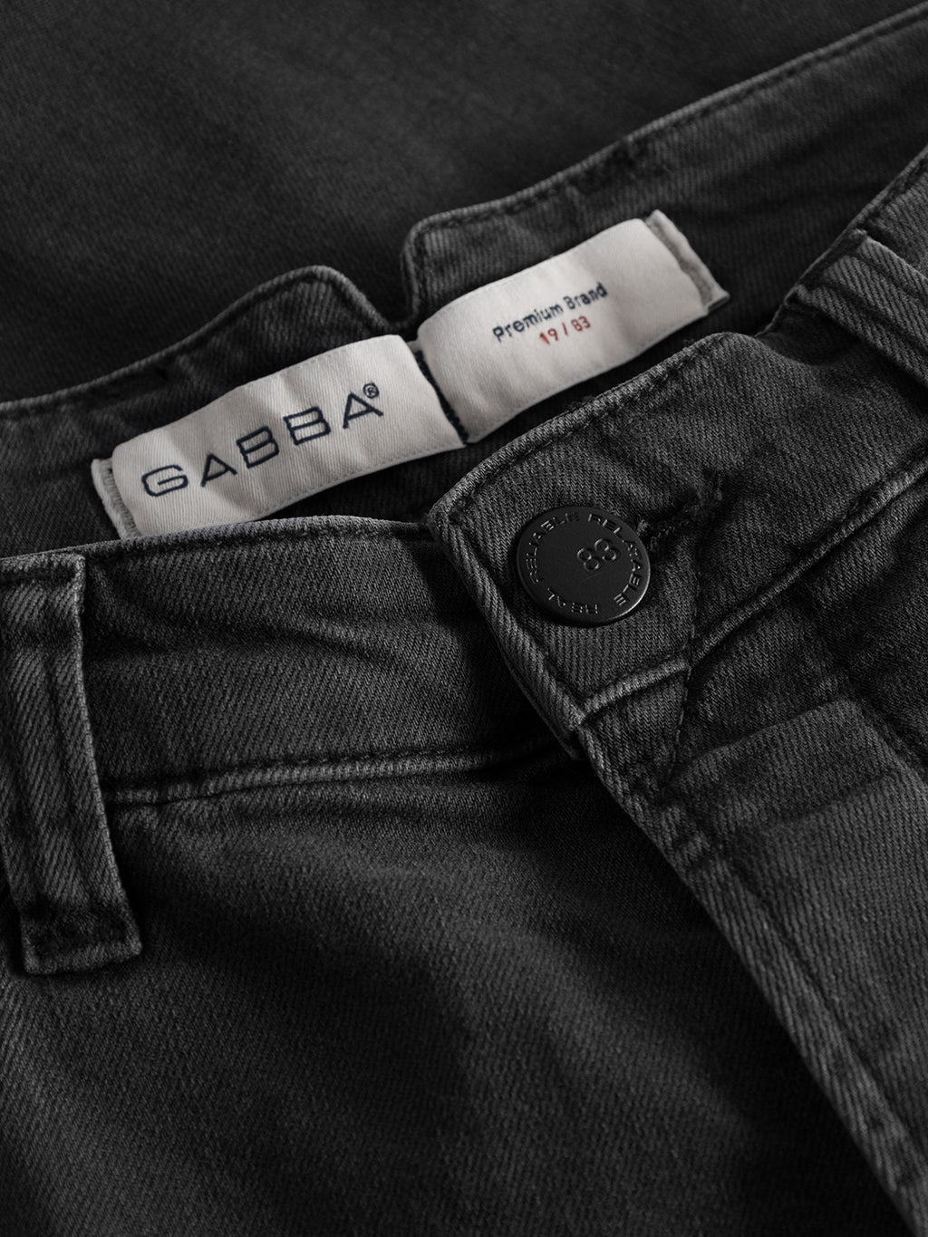 Close-up of GABBA GABalex Thor Cropped Jeans in denim wash, featuring a metal button and interior white label for a fashion-forward look with worker cut waistbands.