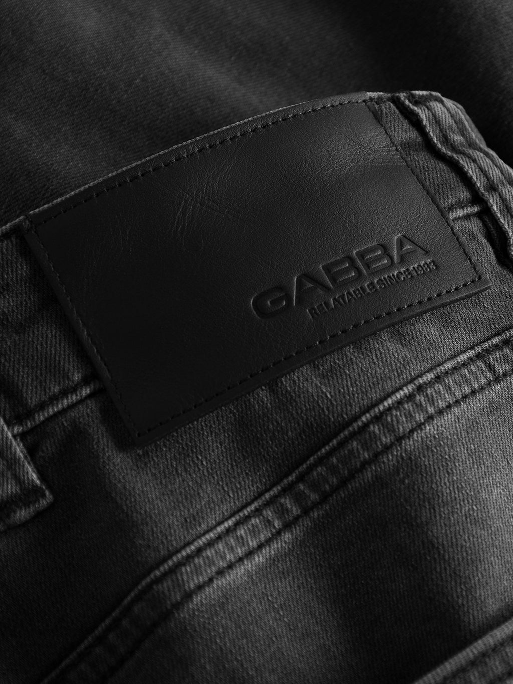 Close-up of GABBA GABalex Thor Cropped Jeans in denim wash, showing a black leather patch with embossed GABBA branding and 