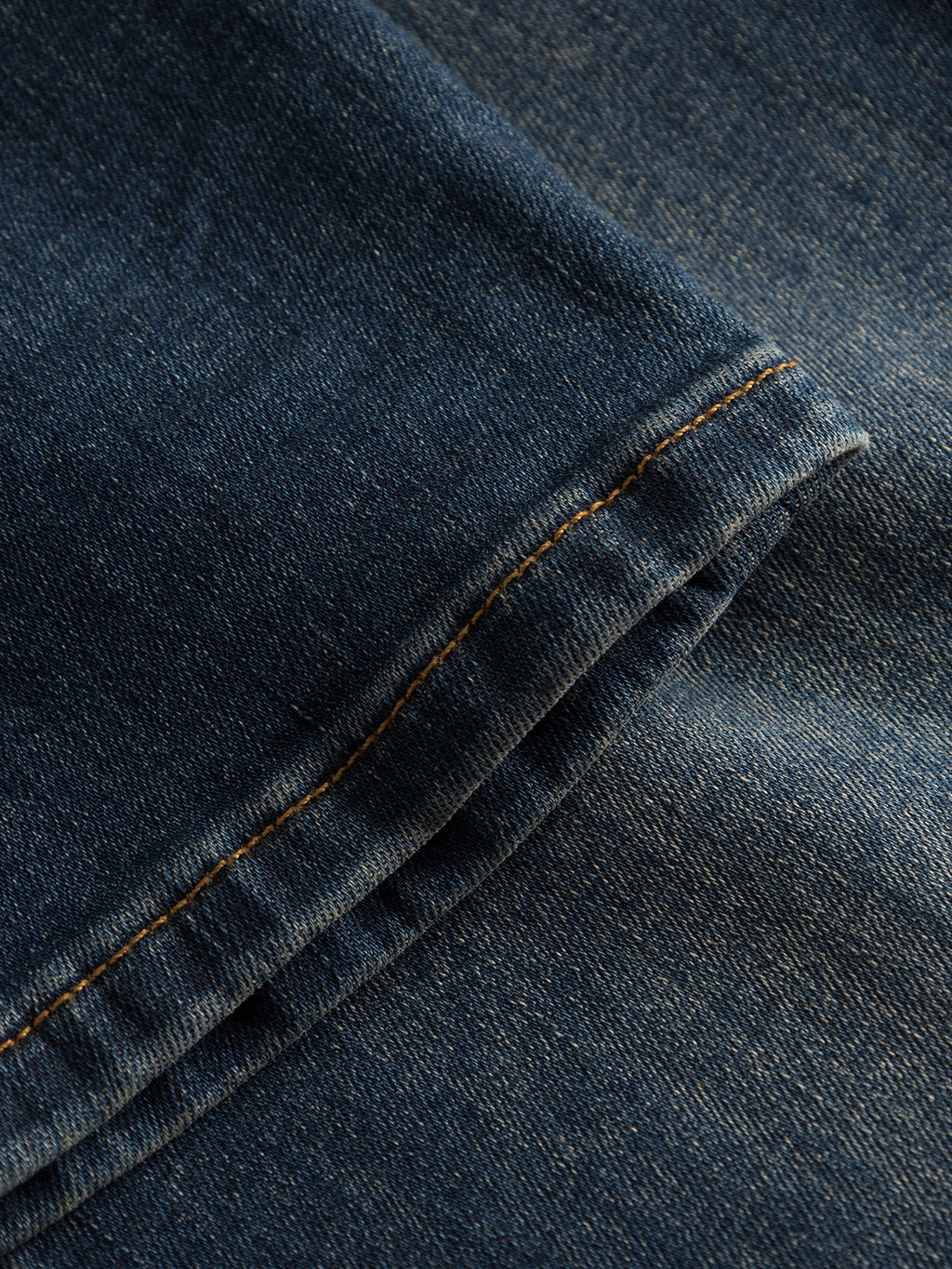 Close-up of GABBA’s GABrey K3606 Mid Blue Jeans in mid blue denim, featuring a neatly sewn seam with orange stitching that highlights the texture and weave typical of this premium fabric.