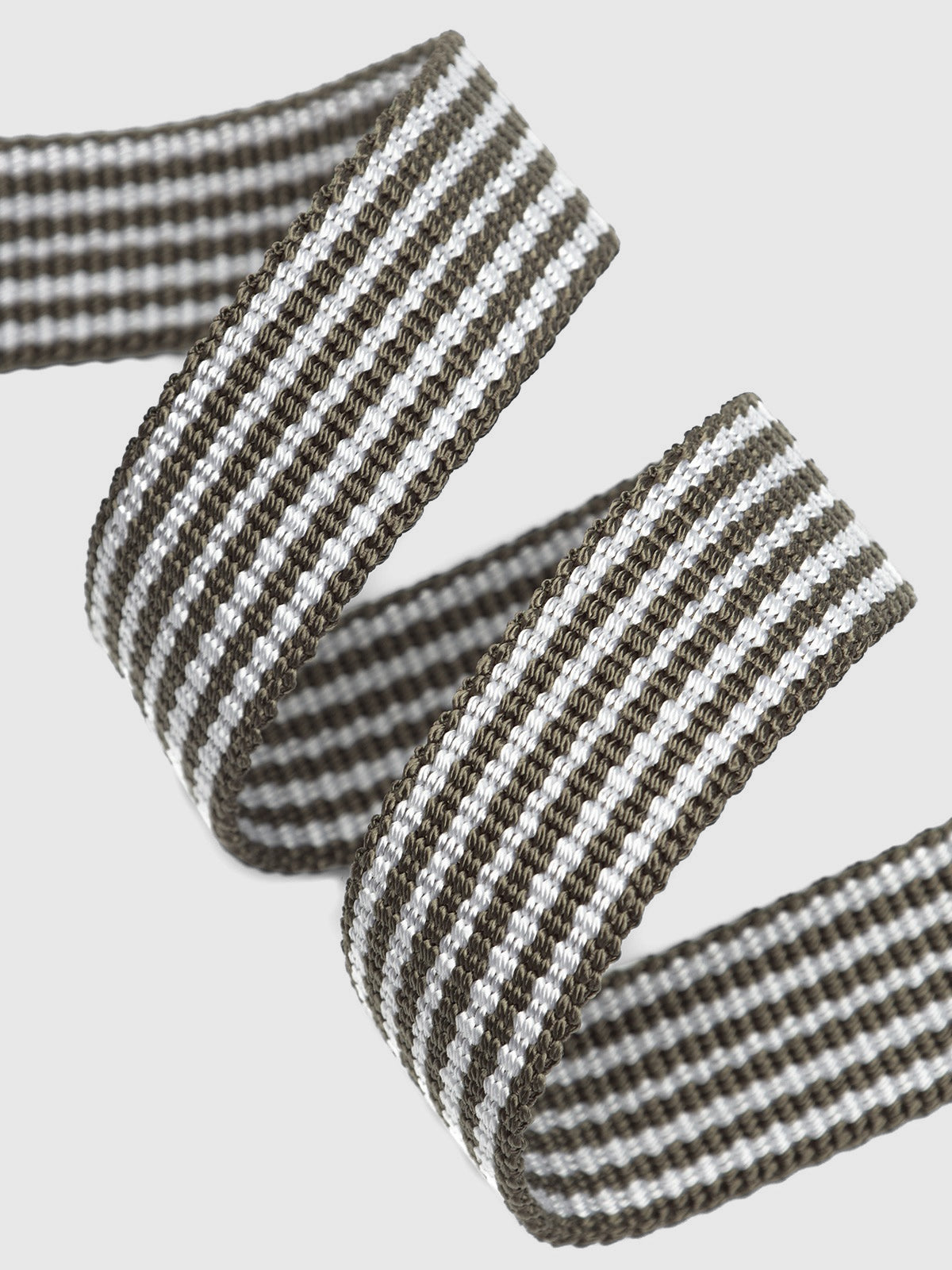 A close-up of Gabbas Manica Belt - Green Stripe showcases its high-quality, woven appearance on a plain white background. The intricate pattern and texture resemble a finely crafted nylon belt, with sharp focus highlighting the alternating black and white lines.
