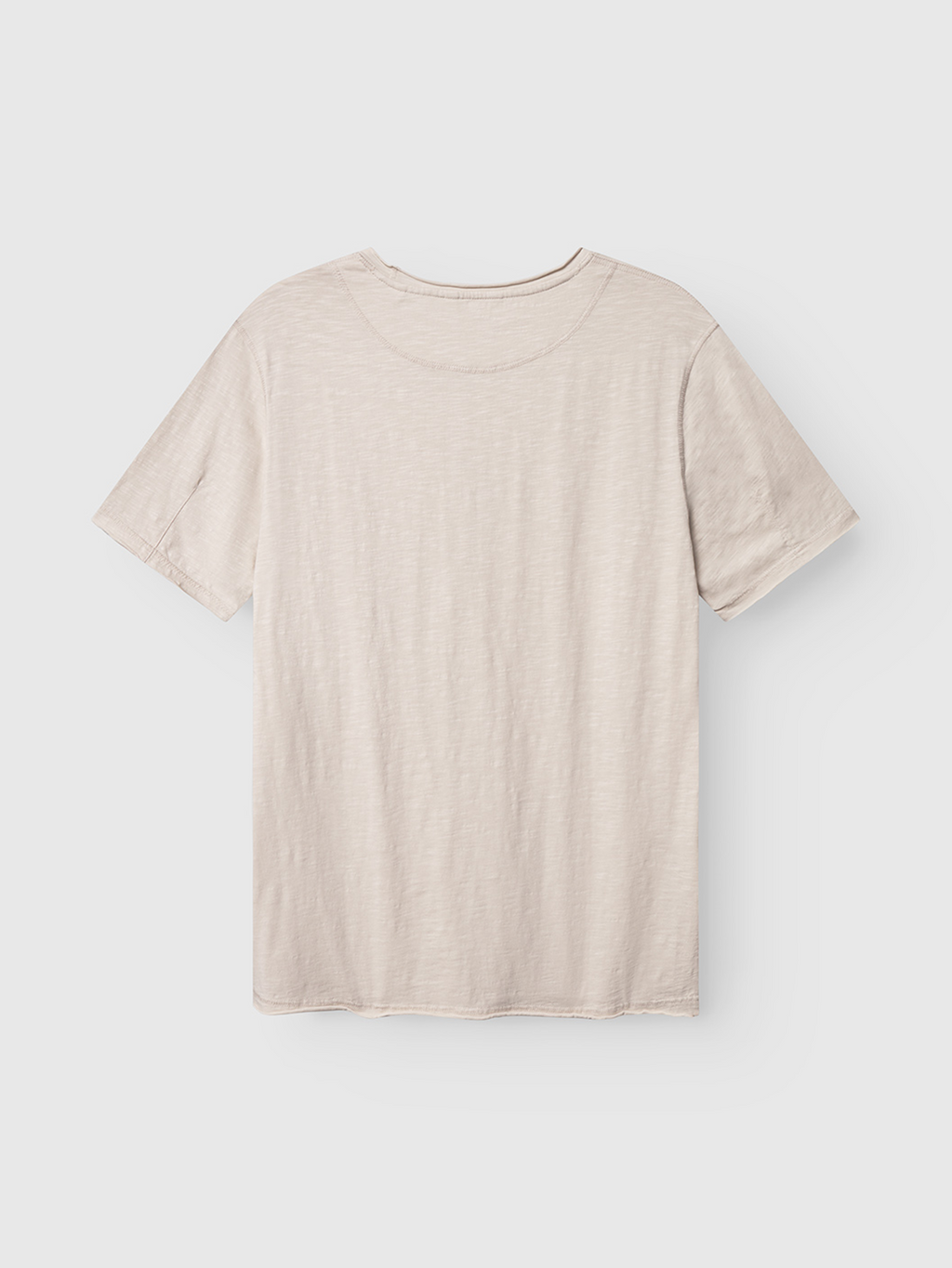 The Gabba Kostant New SS t-shirt in White Almond, featuring a subtle slub texture, is shown laid flat with the back side up on a white background.
