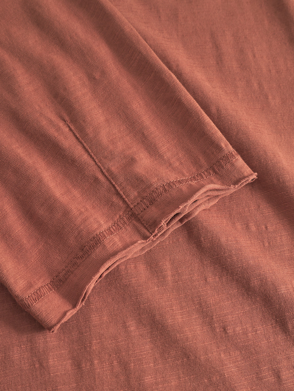 Close-up of the Kostant New SS - Brown Rust by Gabba, highlighting the soft rust fabric, visible edge stitching, smooth texture, and neatly finished hem for a vintage-inspired look.