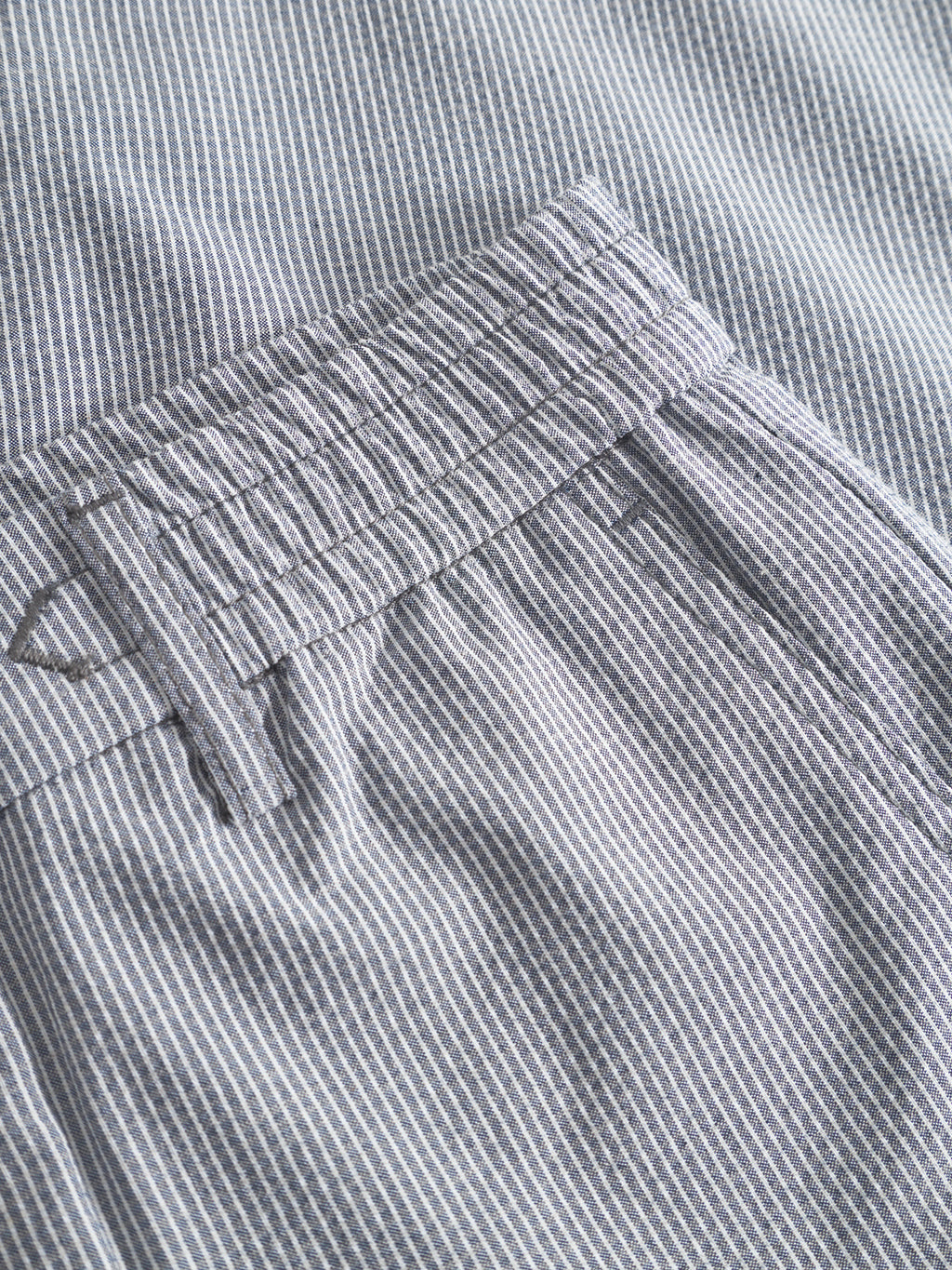 Close-up of Gabba Monza Button Com2 - Navy pants, highlighting the waistband, belt loop, and pocket details on light gray and white vertically striped fabric.