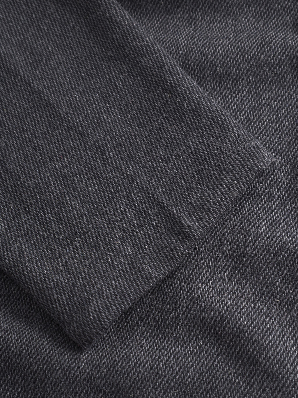Close-up of overlapping Monza Wook - Dk. Grey denim by Gabba, highlighting the diagonal weave and stitching, evoking expertly tailored trousers with a regular tapered fit.