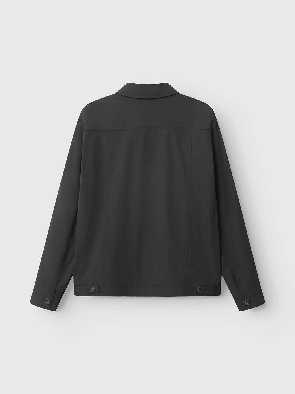 The Gabba Koy Tech - Black utility jacket is shown from the back, with long sleeves, a flat collar, and two adjustable waist button tabs. Its simple design stands out against a plain white background.