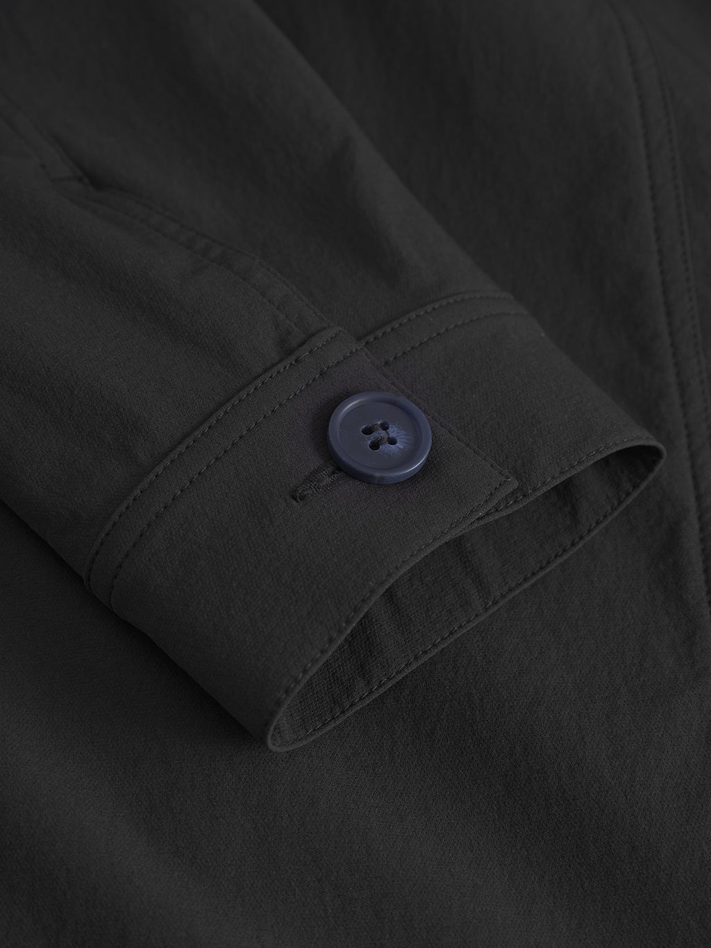 Close-up of the Koy Tech - Black denim jacket by Gabba, highlighting the dark long-sleeve cuff with a dark blue button, visible stitching, and smooth fabric texture.