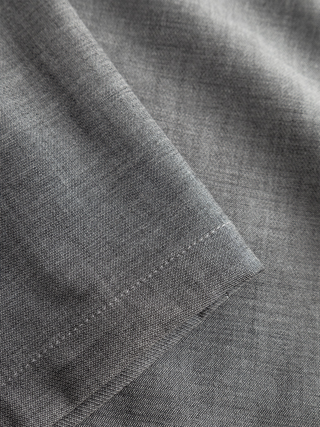 A close-up of Gabbas Napoli 19 Phin GRS trousers in light grey, featuring fine weave fabric and neat hem stitching. The smooth, subtly reflective material is typical of tailored menswear.