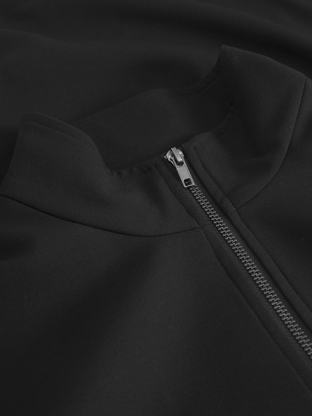 Close-up of the Gabba Nik Phin GRS - Black zip-through jacket, featuring a high collar, silver zipper, modern style, textured fabric, and detailed stitching.