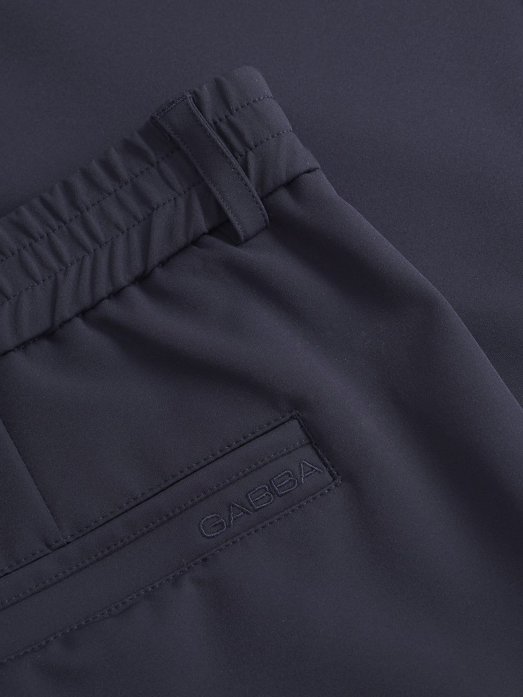 Close-up of the back pocket and elastic waistband of Monza Bascu - Navy straight fit pant in dark navy by Gabba, with Gabba embroidered above the pocket.