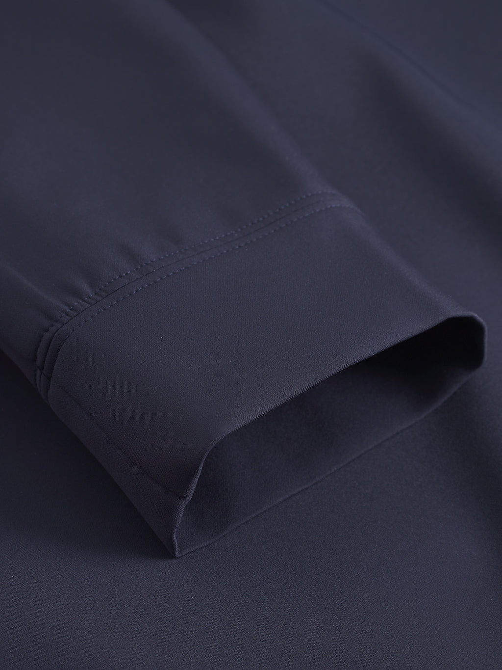 Close-up of the Nik Bascu - Navy jacket cuff by Gabba, highlighting its smooth navy fabric and precise stitching along the edge.