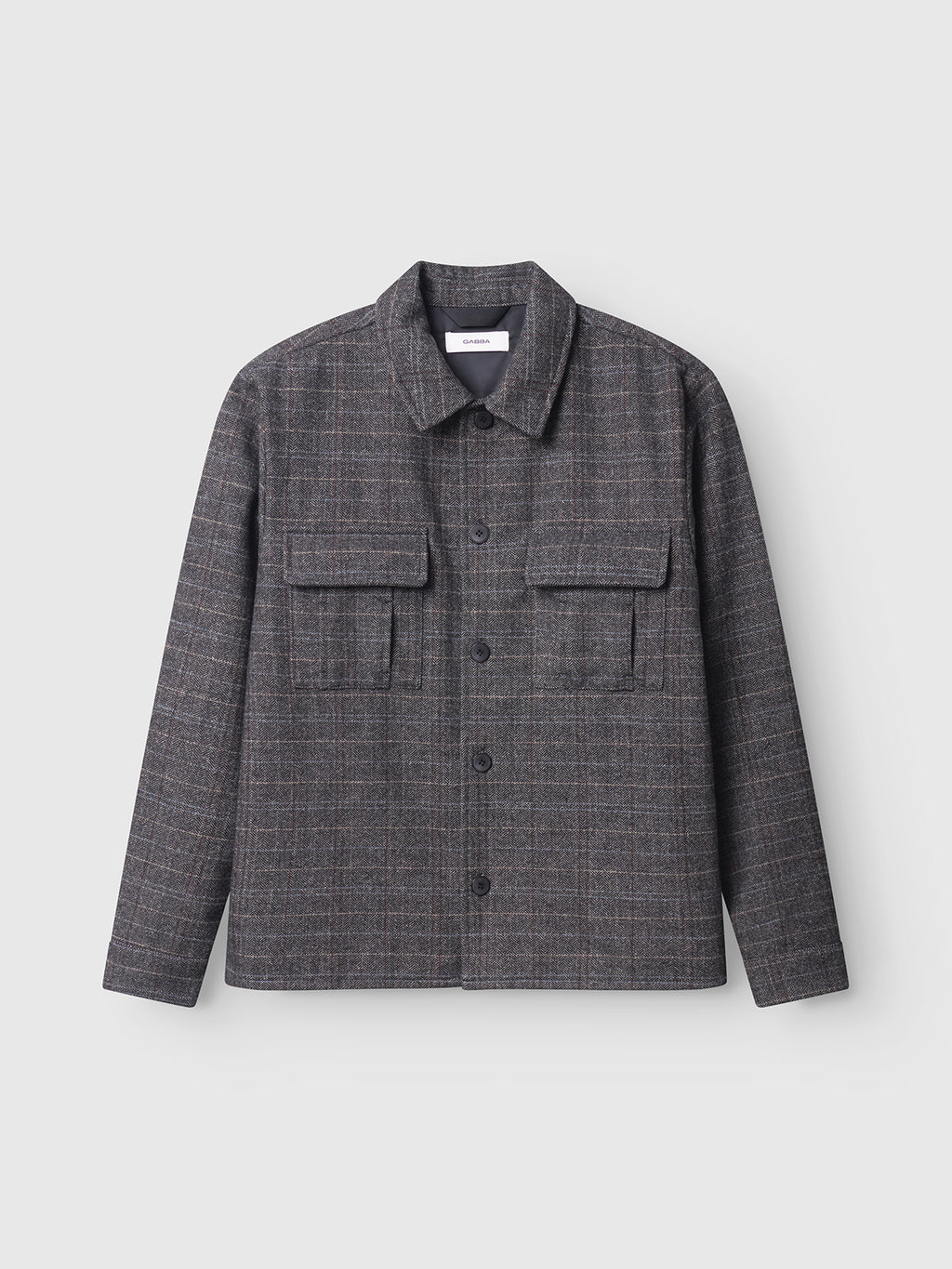 The Gabba Flap Tishi in Brown Check features a checked wool-blend design, collar, and two large chest pockets—an ideal men’s layering piece—shown against a plain light background.