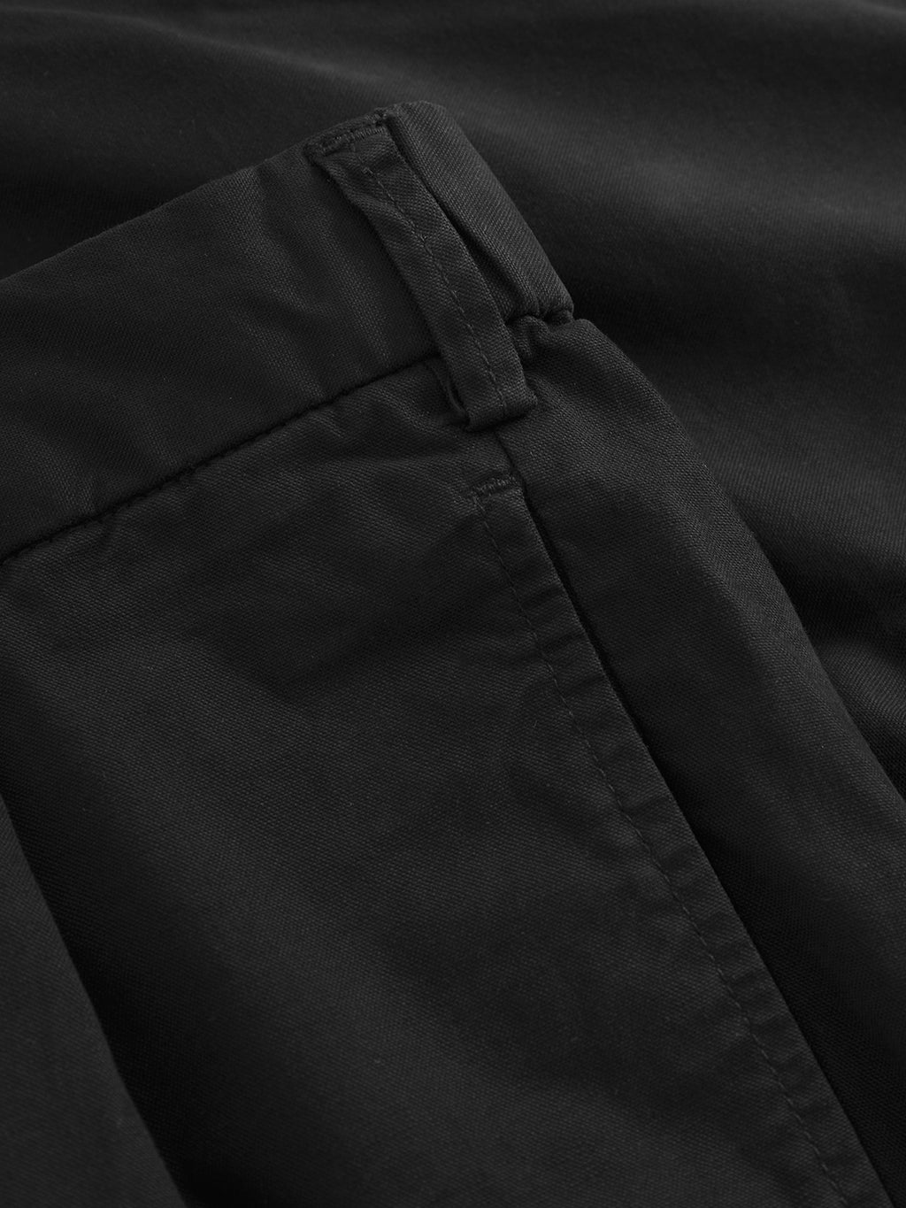 Close-up of the Gabba Imola Kuadro - Black wide-leg pants, highlighting a neatly stitched side pocket, waistband with belt loop, and visible seams. The smooth, slightly matte garment is crafted from garment-dyed stretch fabric.