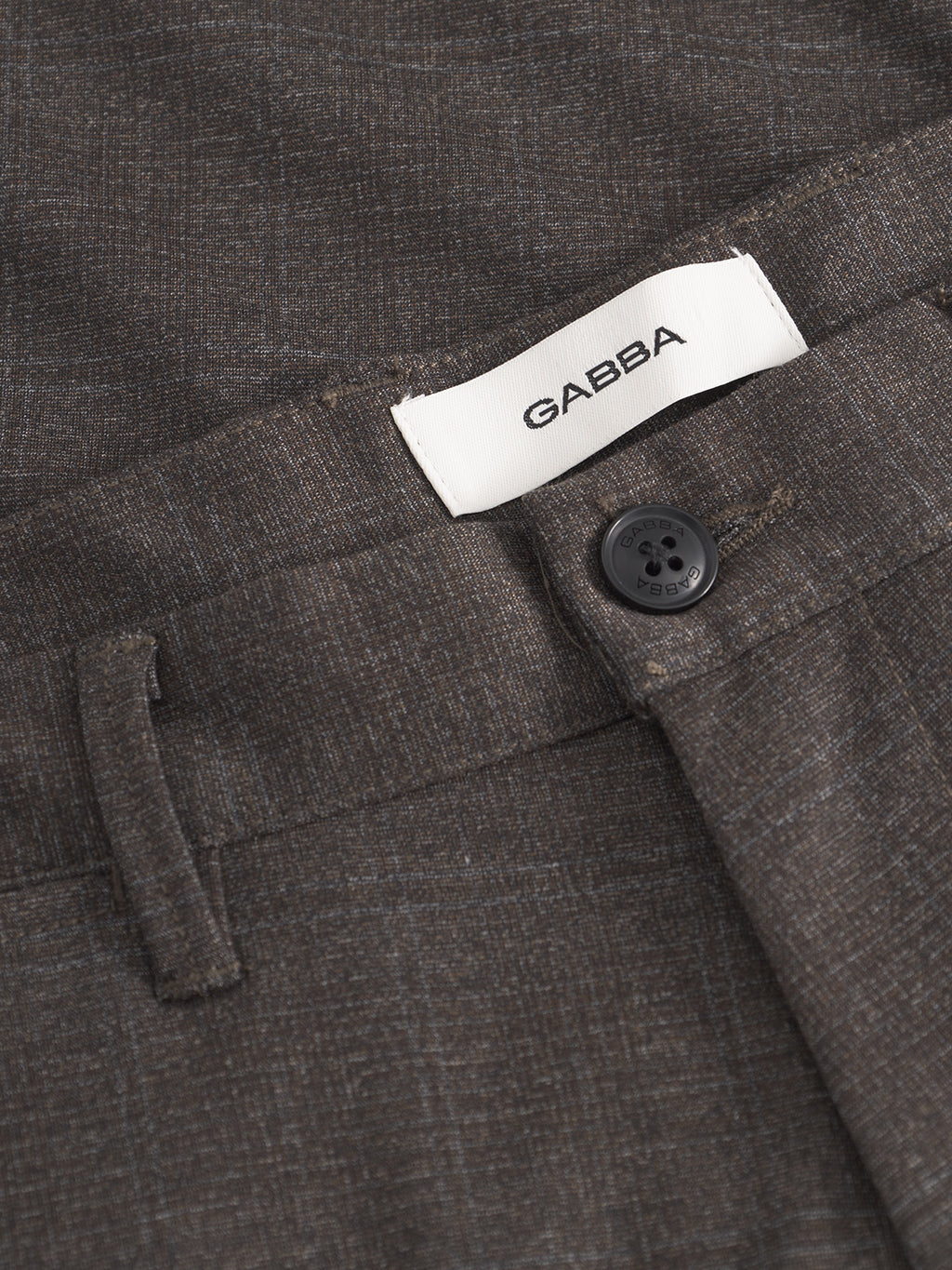Close-up of Gabba Paul Nygo slim straight trousers in dark brown, featuring a black button, white GABBA label inside the waistband, visible belt loop, stretch comfort fabric, and subtle pattern.