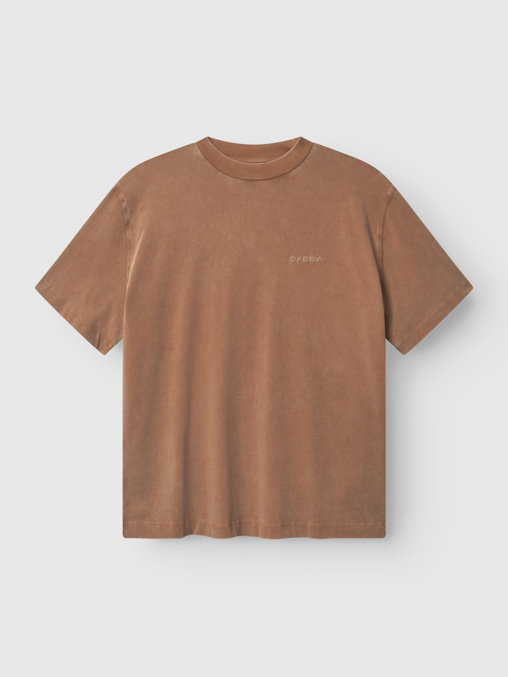 The Gabba Nigel Wix Boxy Peso SS in bronze brown is a boxy-fit tee made from durable cotton jersey, featuring a vintage faded look, crew neck, and subtle chest logo. Shown on a flat white background.