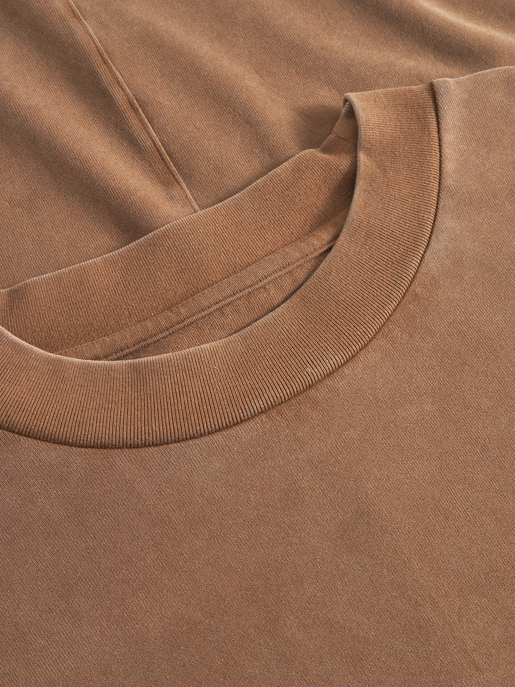 Close-up of the Gabba Nigel Wix Boxy Peso SS T-shirt in bronze brown, highlighting the crew neckline, fine ribbed collar, visible fabric texture, and stitching details of this durable cotton boxy-fit logo tee.
