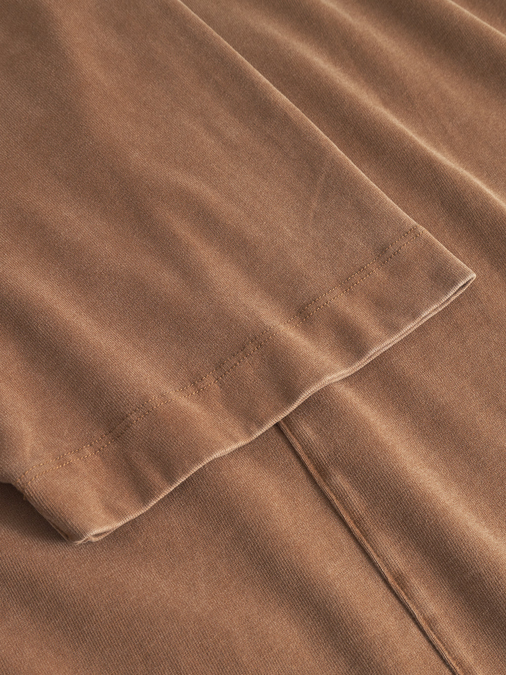 Close-up of the hem and seam detail on the Gabba Nigel Wix Boxy Peso SS in bronze brown, highlighting the texture and stitching of its durable cotton jersey fabric.