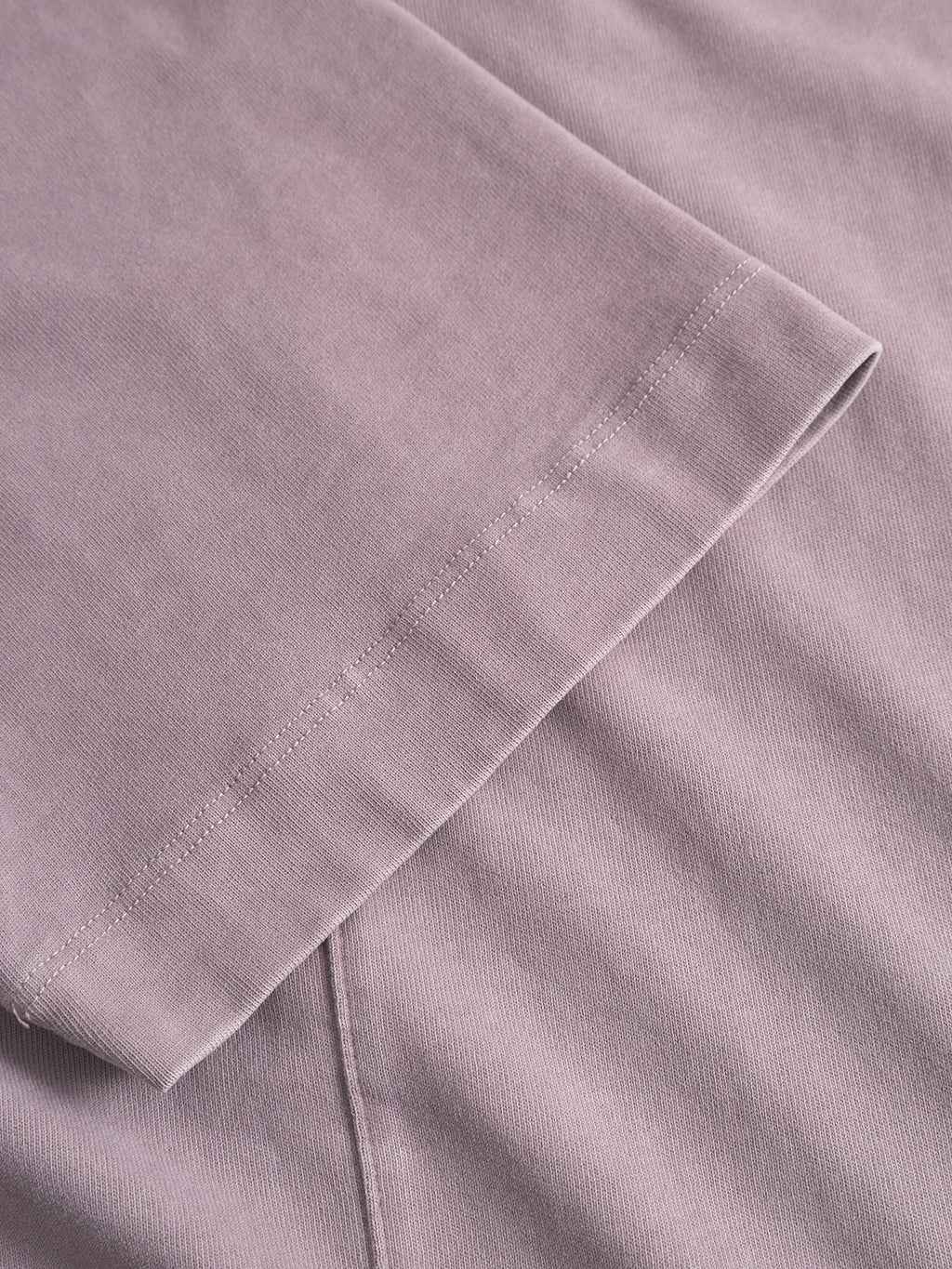 Close-up of the sleeve and body of the Gabba Nigel Wix Boxy Peso SS in Dust Purple, showcasing its stitching detail and soft cotton jersey fabric.