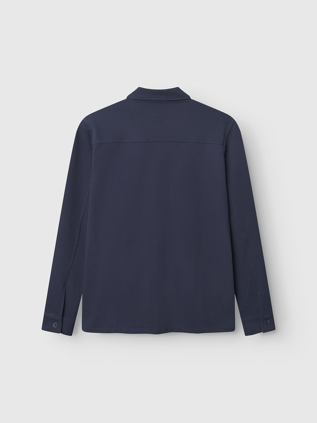 The Gabba Como Waff - Navy is a long-sleeve, navy overshirt made from recycled cotton, featuring a collar and buttoned cuffs. Shown from the back against a plain light gray background.