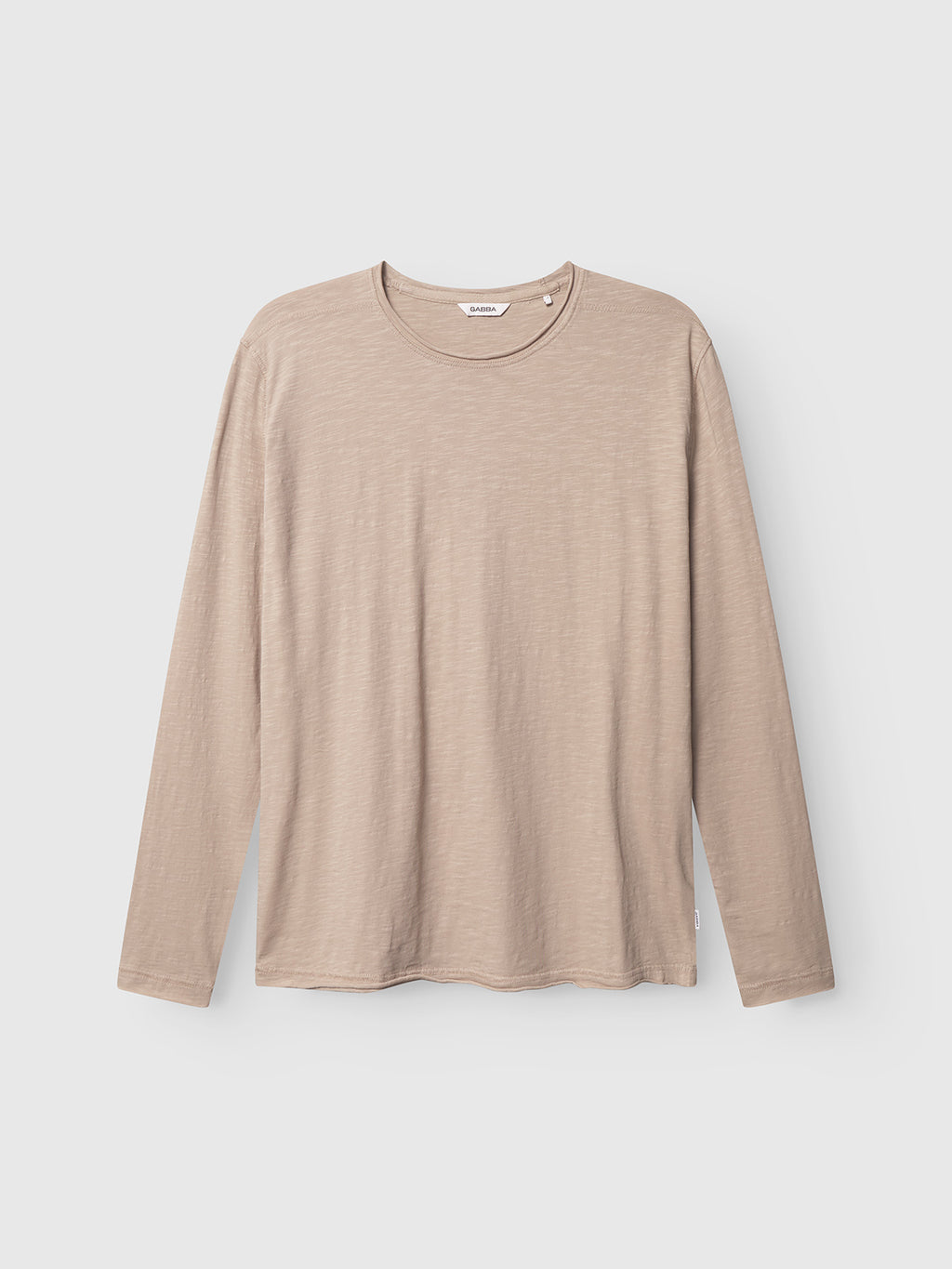 The Gabba Kostant New LS in Humus is a beige, plain long-sleeved tee made from midweight slub jersey with a crew neck, shown laid flat on a white background.