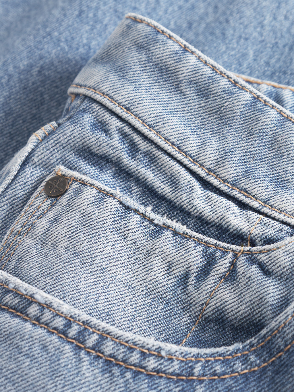 Close-up of the front and coin pockets of Gabba Carl Prag - Lt. Blue Denim jeans, featuring visible stitching, a worn effect, and a small metal rivet.