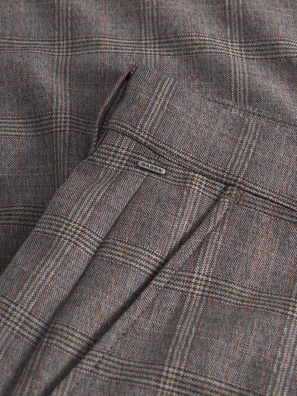 Close-up of Paul Tinun slim straight pants in brown check by Gabba. Features include a zipper, waistband, small metal brand tag, and textured stretch-woven fabric for all-day comfort.
