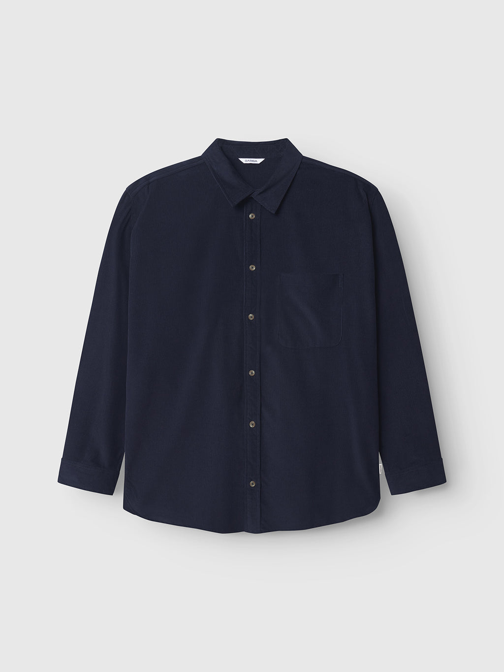 The Gabba Jens Over Cord LS in Night Sky is a navy blue, long-sleeve corduroy overshirt with a chest pocket, shown on a plain light gray background—a versatile layering essential.