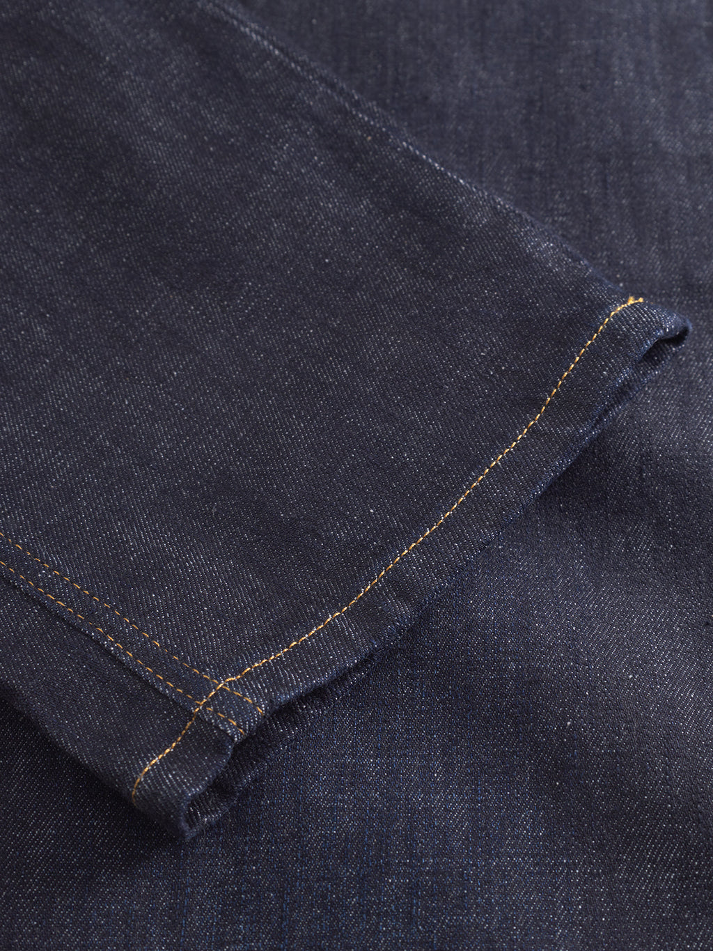 Close-up of the hem and stitching on Gabbas Max Work Self dark blue denim jeans, featuring yellow thread and classic workwear texture.