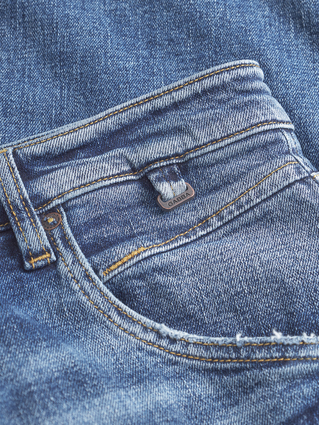 Close-up of Gabba Alex Cros - Mid Blue Denim pocket, featuring visible stitching, a small metal tag, and faded comfort stretch denim for textured style.