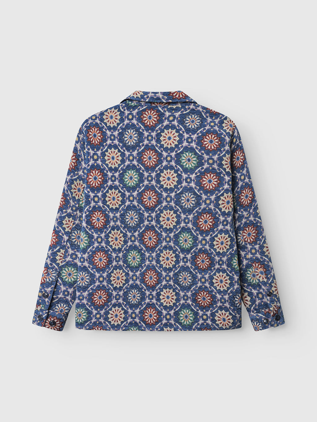 The Gabba Simone Nava LS - Multi Pattern is a striking long-sleeve shirt featuring a blue base with red, white, green, and beige geometric floral designs—shown flat from the back, it’s the ultimate statement layering piece.
