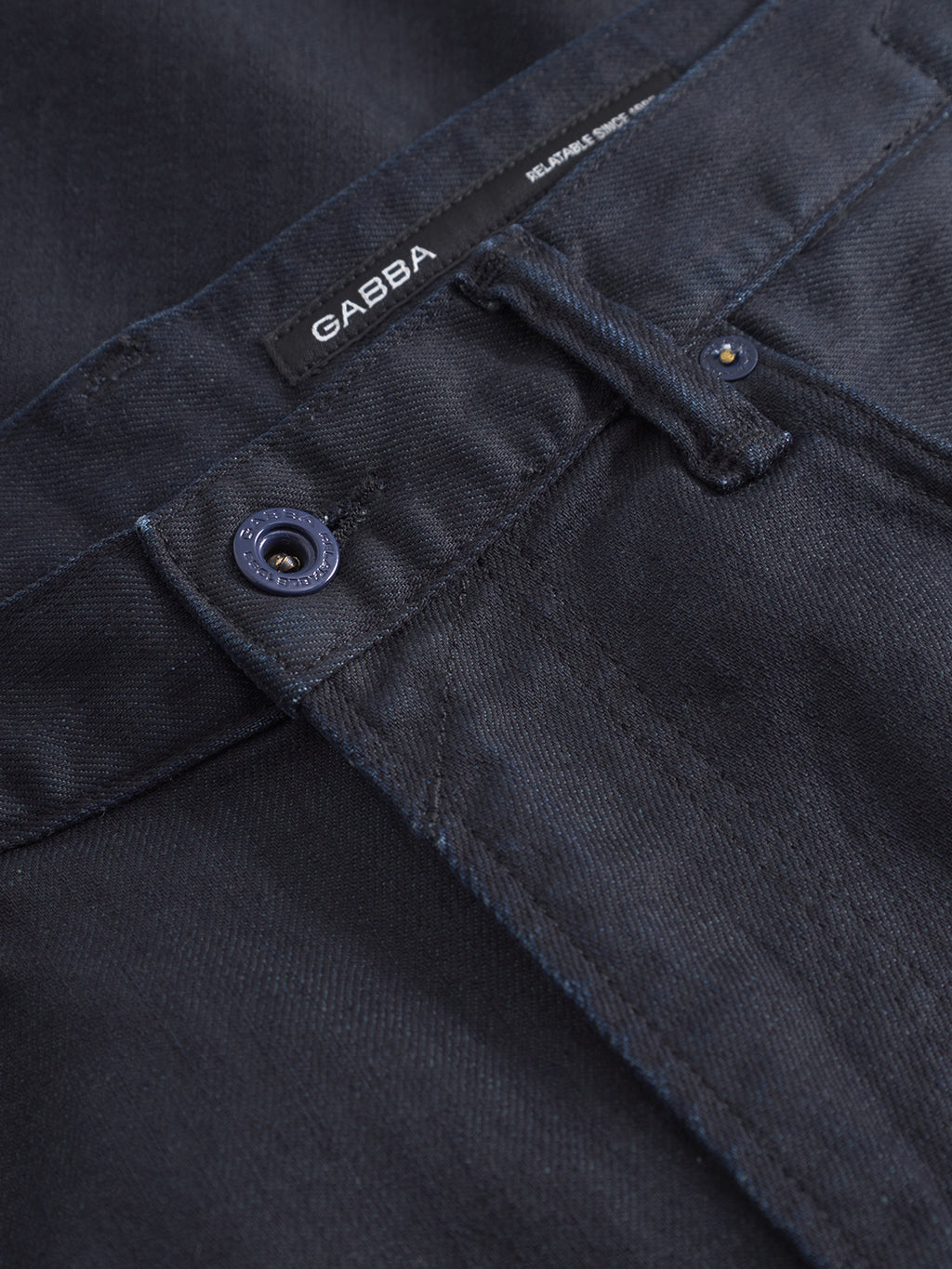 Close-up of the waistband and button on Gabbas Carl Anark Fara dark blue denim jeans, showing the inner brand label, visible texture, stretch comfort, and detailed stitching of the fabric.