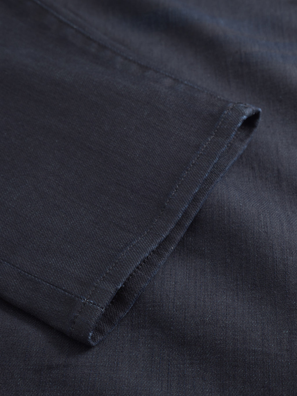 Close-up of the hem and sleeve of a navy blue t-shirt, highlighting the fabric texture and neat stitching—perfect to pair with Gabbas Carl Anark Fara - Dark Blue Denim for casual comfort.