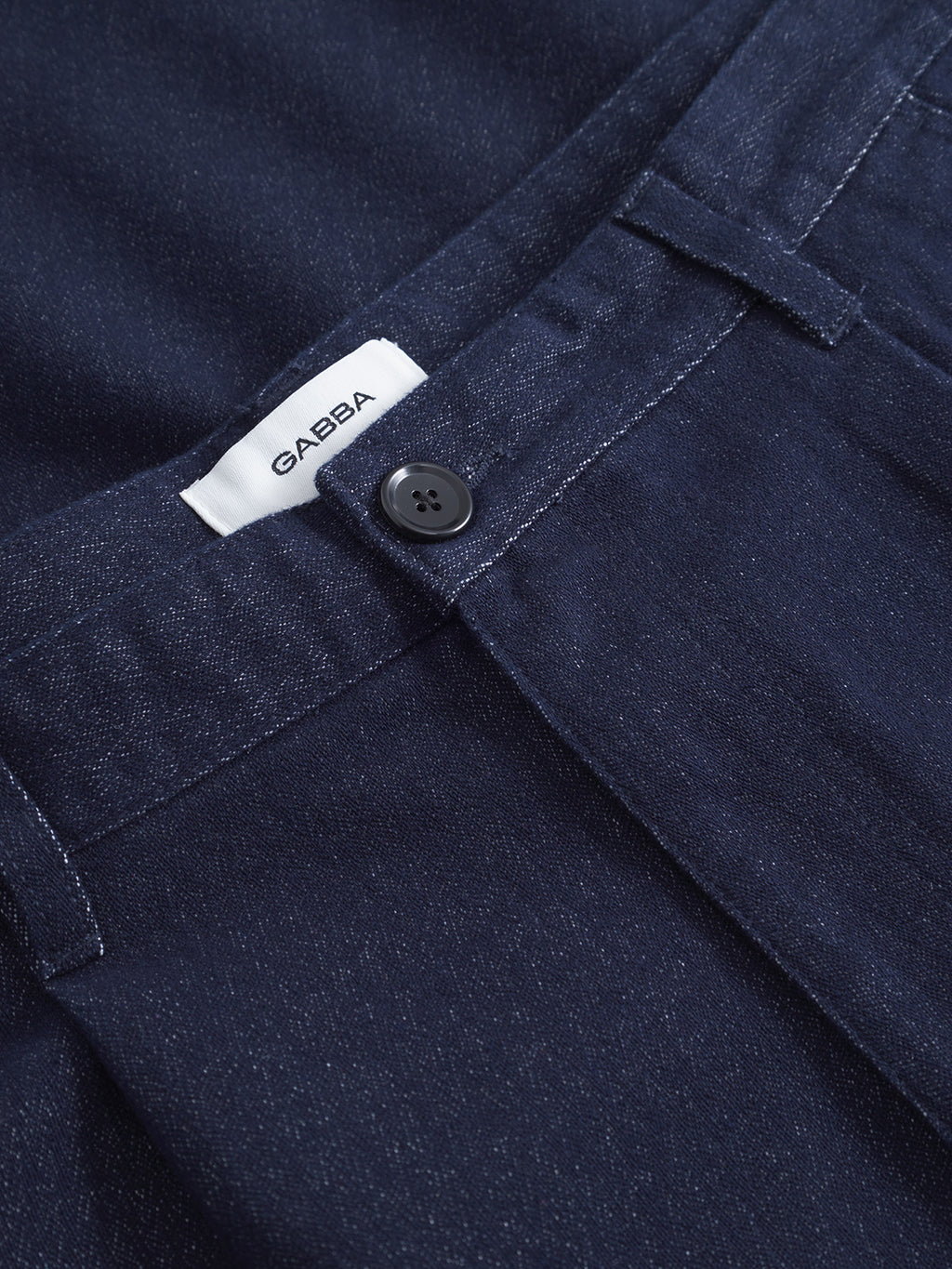 Close-up of Gabba’s David Chev - Dark Navy pants, showcasing a subtle herringbone texture, black button, and a white Gabba label on the waistband.