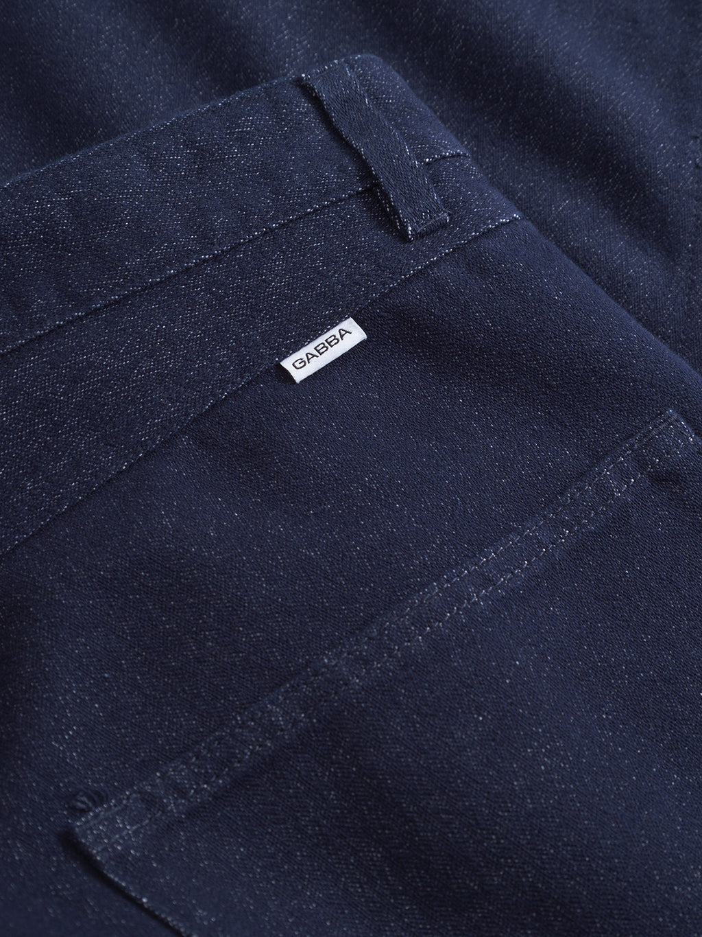 Close-up of David Chev - Dark Navy denim by Gabba, featuring dark navy fabric with visible stitching, a subtle herringbone texture, and a pocket adorned with a small white Gabba label.