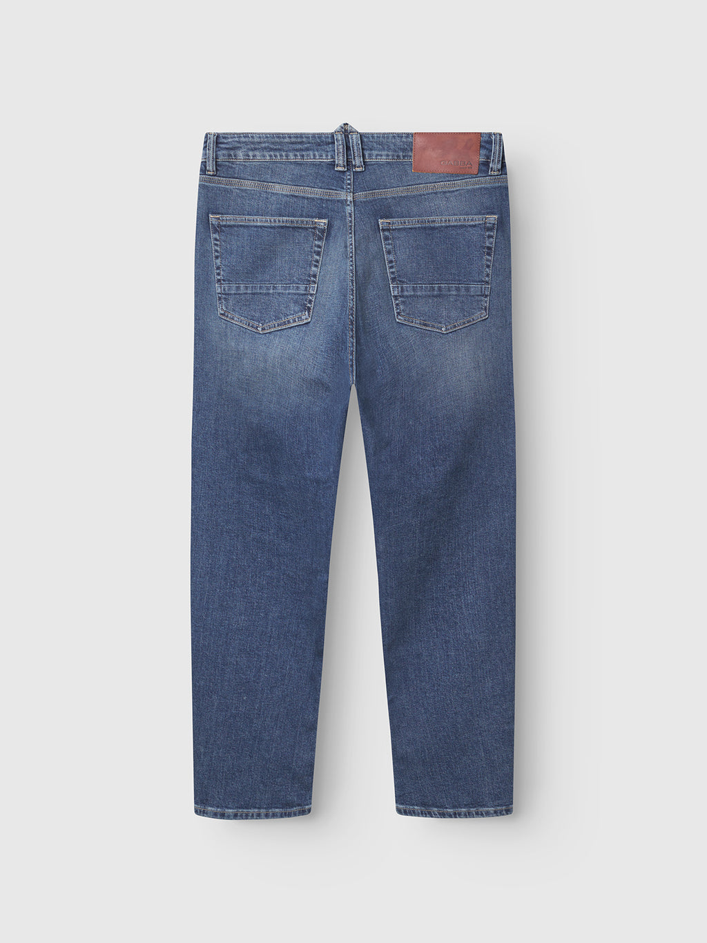 The Gabba Carl Jingo Dark Blue Denim jeans are shown from the back, featuring two back pockets, contrast stitching, and a brown waistband patch. Relaxed fit style, laid flat on a plain light background.