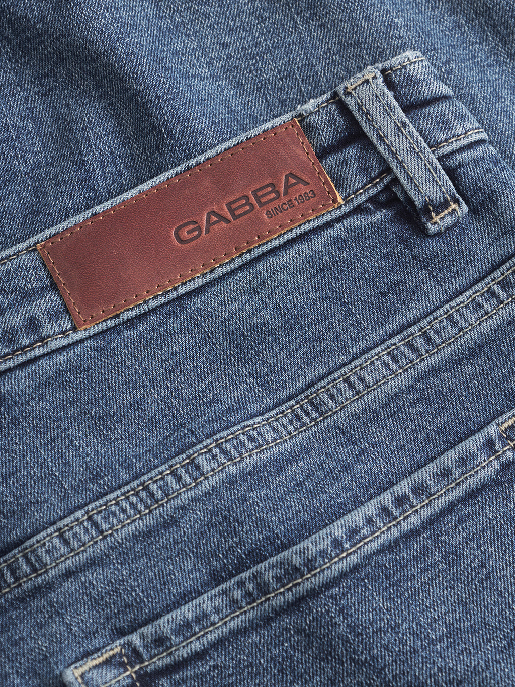 Close-up of Marc Jingo - Dark Blue Denim straight-leg jeans by Gabba, featuring a brown leather patch embossed with the brand name and Since 1983, plus visible seams and pockets for comfort stretch.