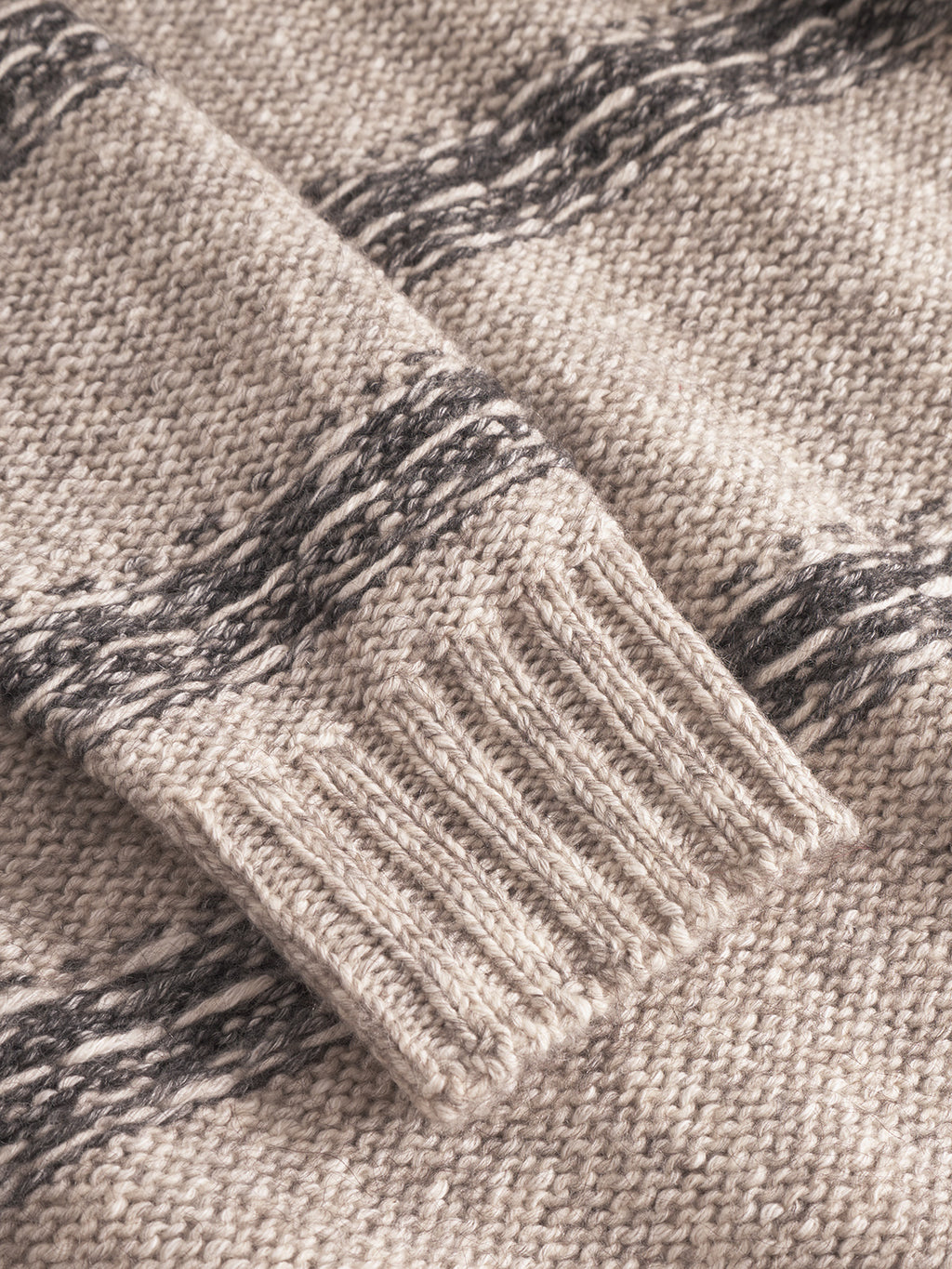Close-up of the Gabba Osaka Fay LS - Ecru: a beige long-sleeve top with black horizontal stripes and ribbed cuffs, showcasing its textured melange yarn pattern.