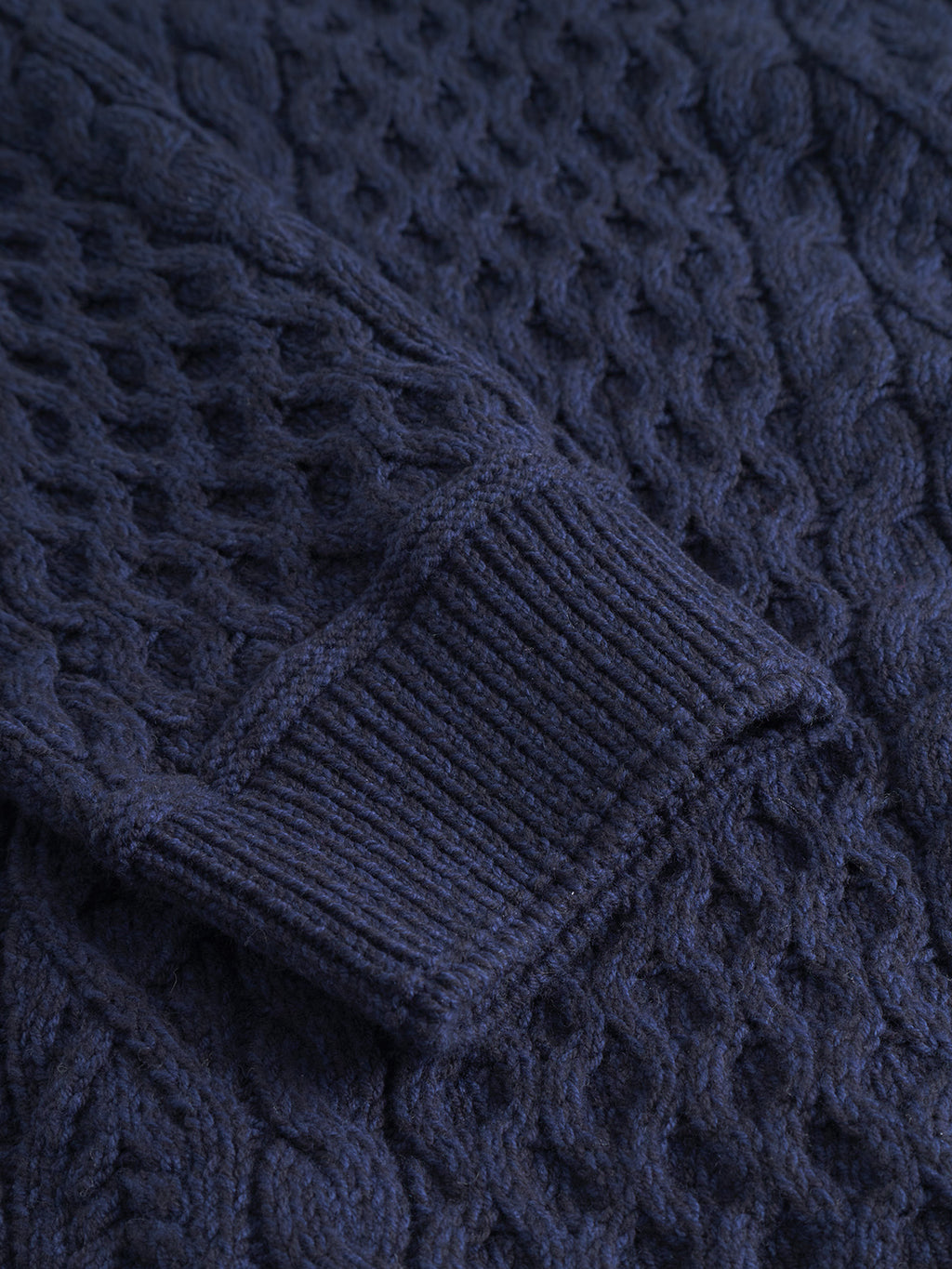 Close-up of the Gabba Tokyo Cable LS in navy, showing a ribbed cuff and textured cable knit—an ideal addition to men’s knitwear collections.