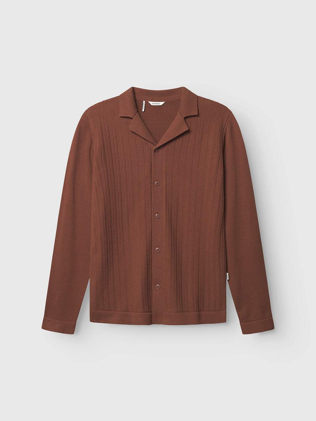 The Gabba Sakai Wong LS in brown rust features a textured vertical rib pattern, long sleeves, resort-style collar, and straight hem, displayed against a plain light background.