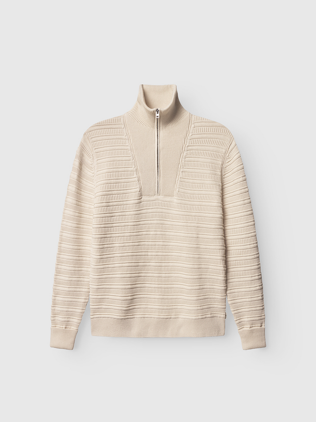 The Gabba Iwaki Buco LS in White Almond is a beige, long-sleeve cotton jumper featuring a ribbed texture, horizontal stripes, high collar, and trendy quarter-zip front.