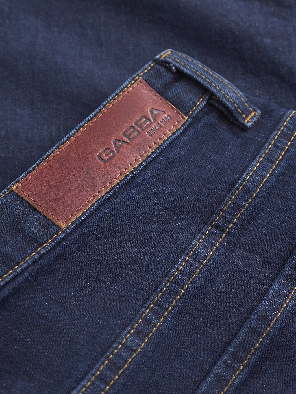 Close-up of Gabba Marc Jingo dark blue denim jeans with comfort stretch, brown leather Gabba patch, visible stitching, and a belt loop.