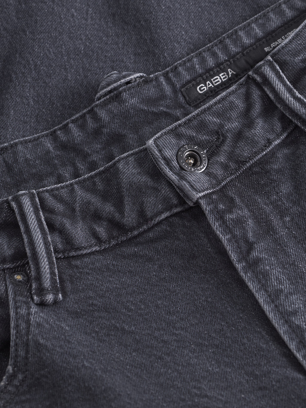 Close-up of the waistband and button on Gabbas Carl Puma - Black Denim jeans, showcasing visible stitching and a black GABBA label near the waistband.