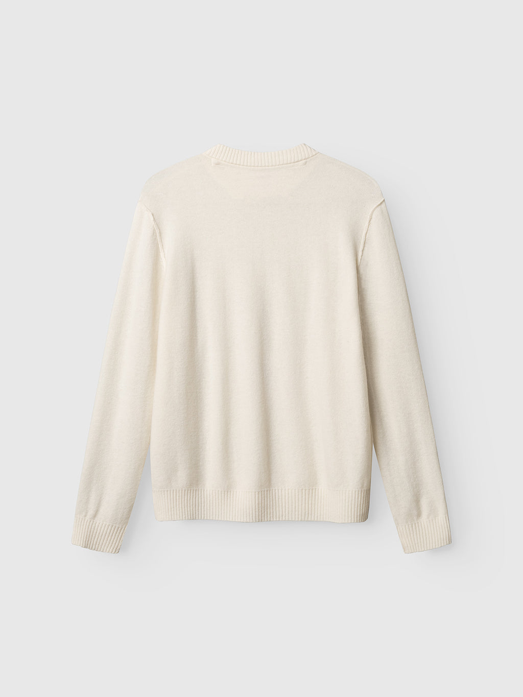 The Gabba Tokota Aico LS sweater in off white is shown laid flat with the back up. Made from merino wool, it features ribbed neckline, cuffs, and hem—perfect as a cozy layering piece for cool days.