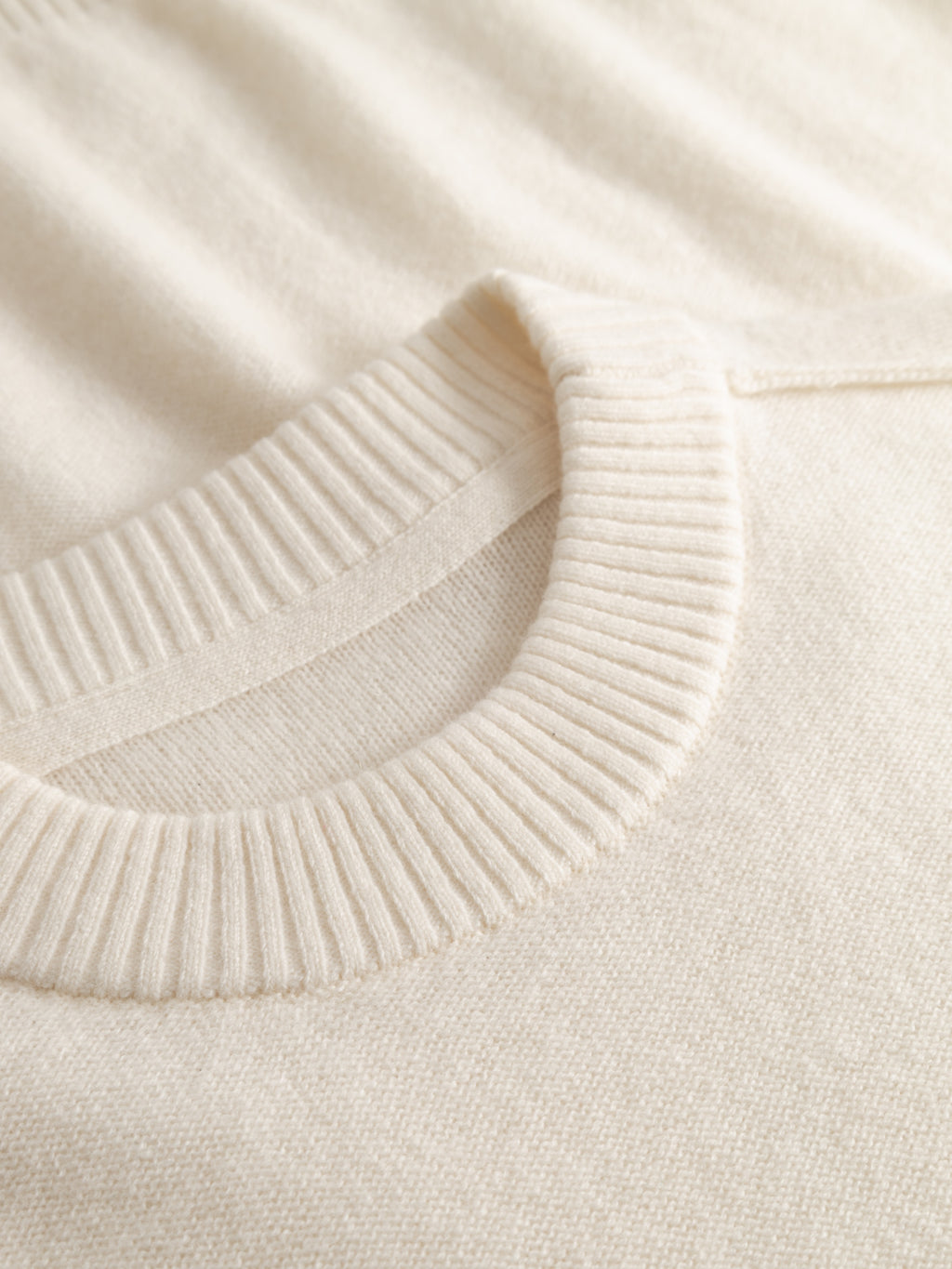 Close-up of the Gabba Tokota Aico LS in Off White, showcasing a ribbed round neckline and soft, textured fabric—ideal as a cozy wool layering piece.