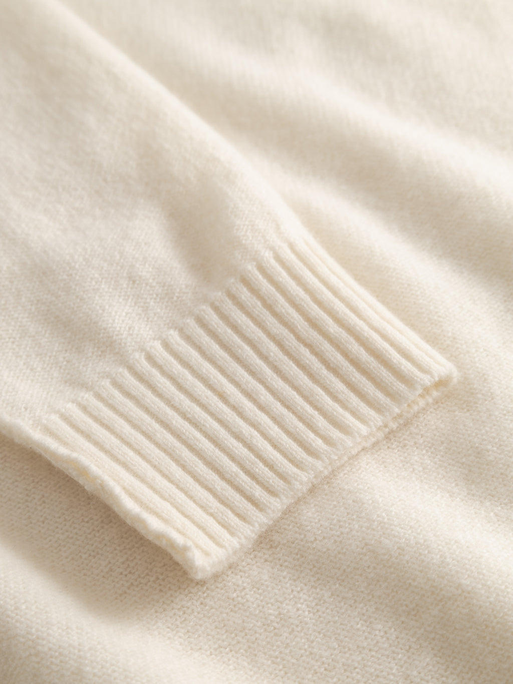 Close-up of the Tokota Aico LS sweater by Gabba in off white, featuring a ribbed cuff, soft texture, and fine stitching—an ideal wool layering piece for warmth and style.
