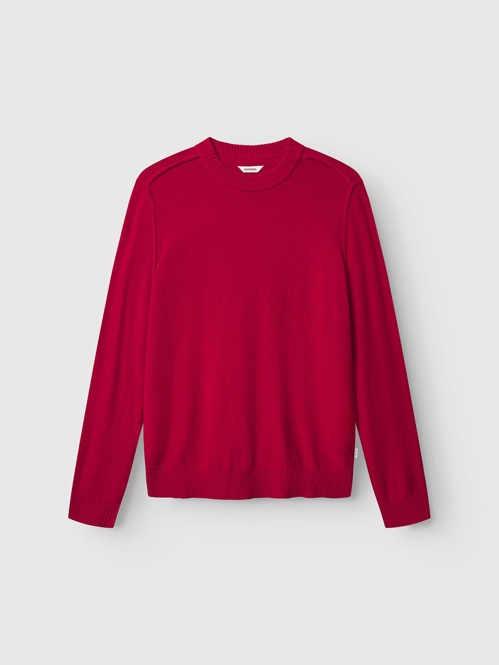 The Gabba Tokota Aico LS - Red is a modern Merino wool sweater with long sleeves, a crew neckline, ribbed cuffs and hem, shown on a light gray background.