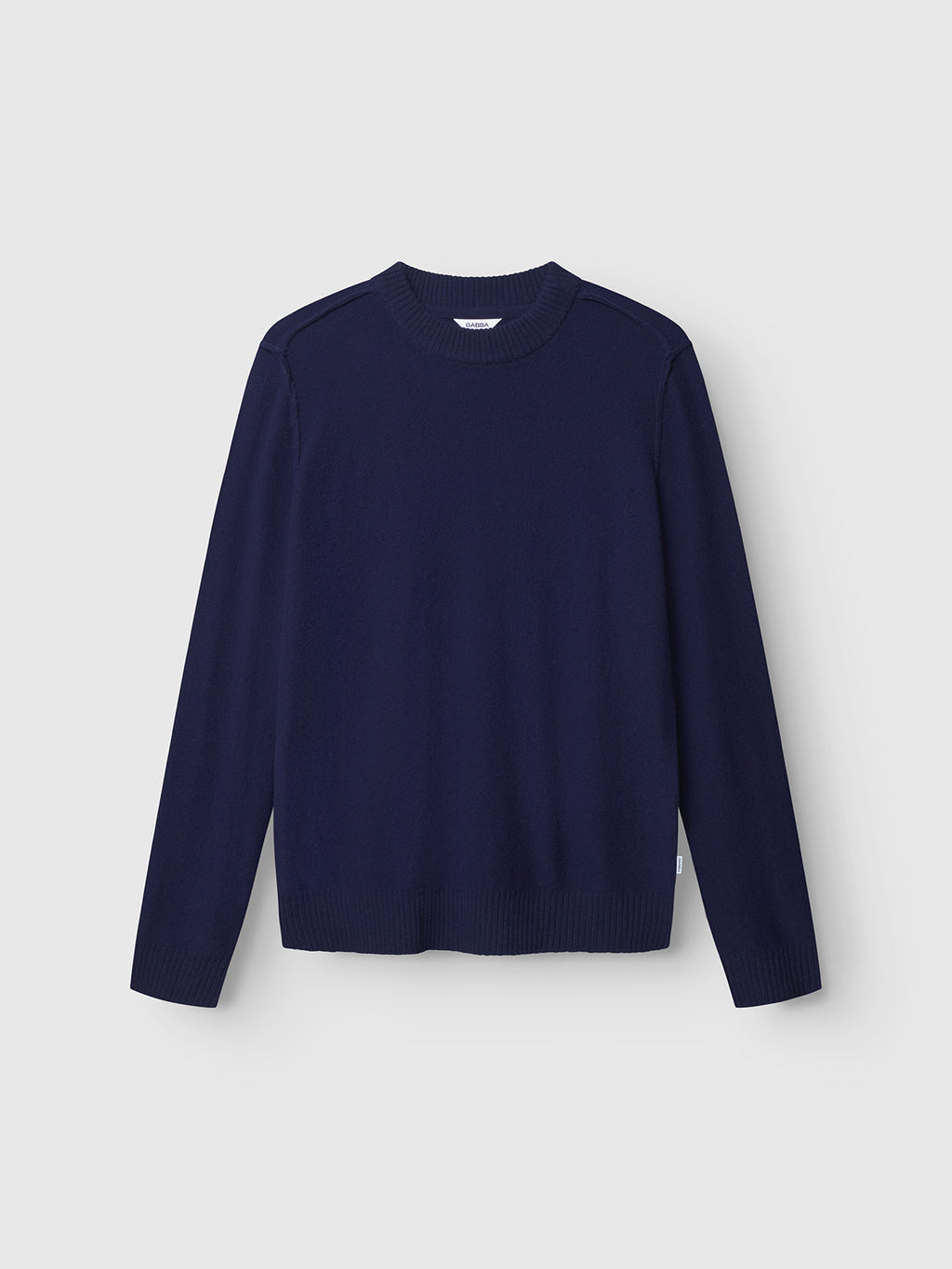 The Gabba Tokota Aico LS in Dark Navy is a versatile crewneck sweater with long sleeves and ribbed neckline, cuffs, and hem, shown against a light gray background.