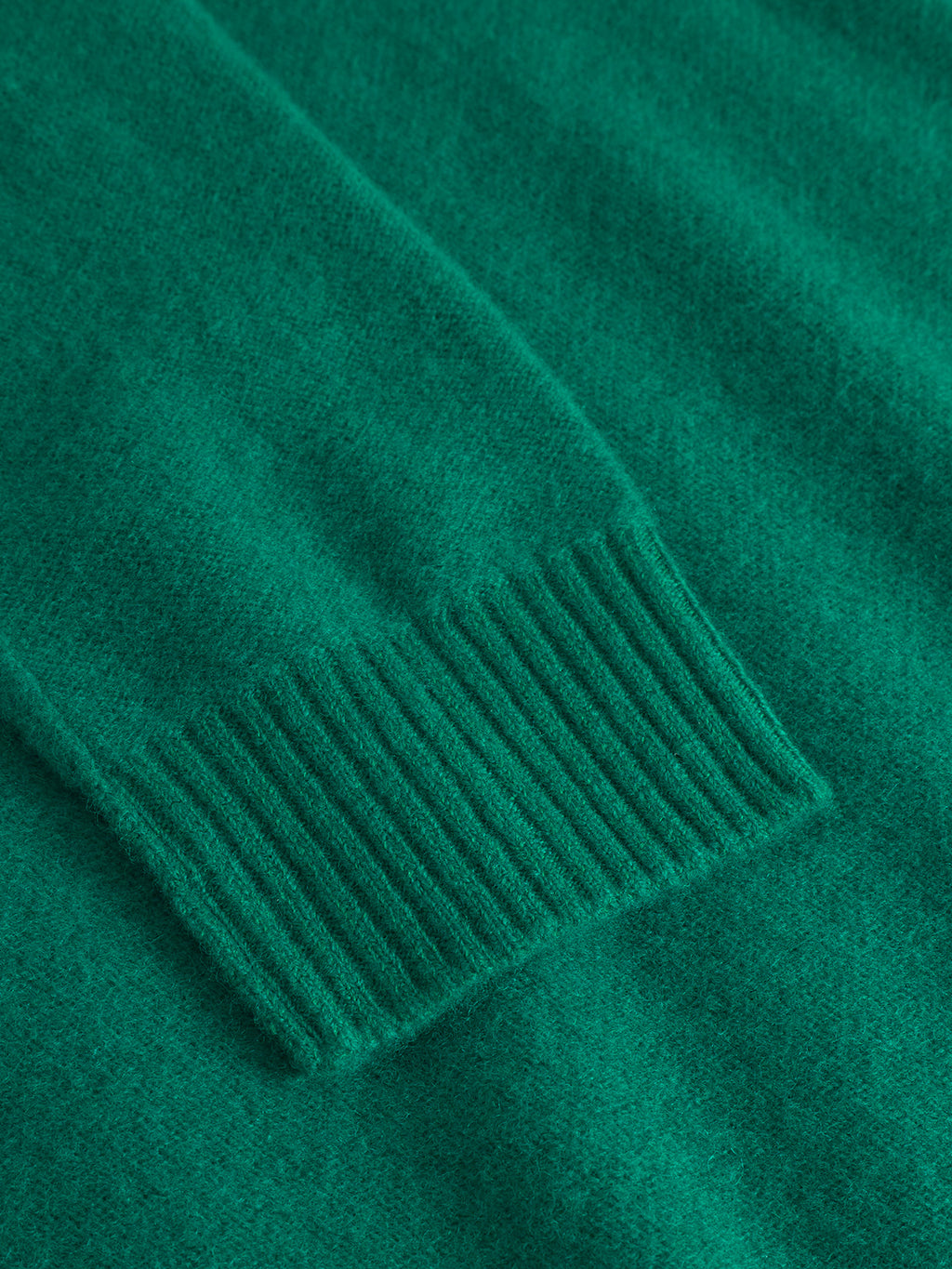 Close-up of the Tokota Aico LS - Green by Gabba, highlighting the ribbed cuff and soft texture of this pure merino wool sweater.