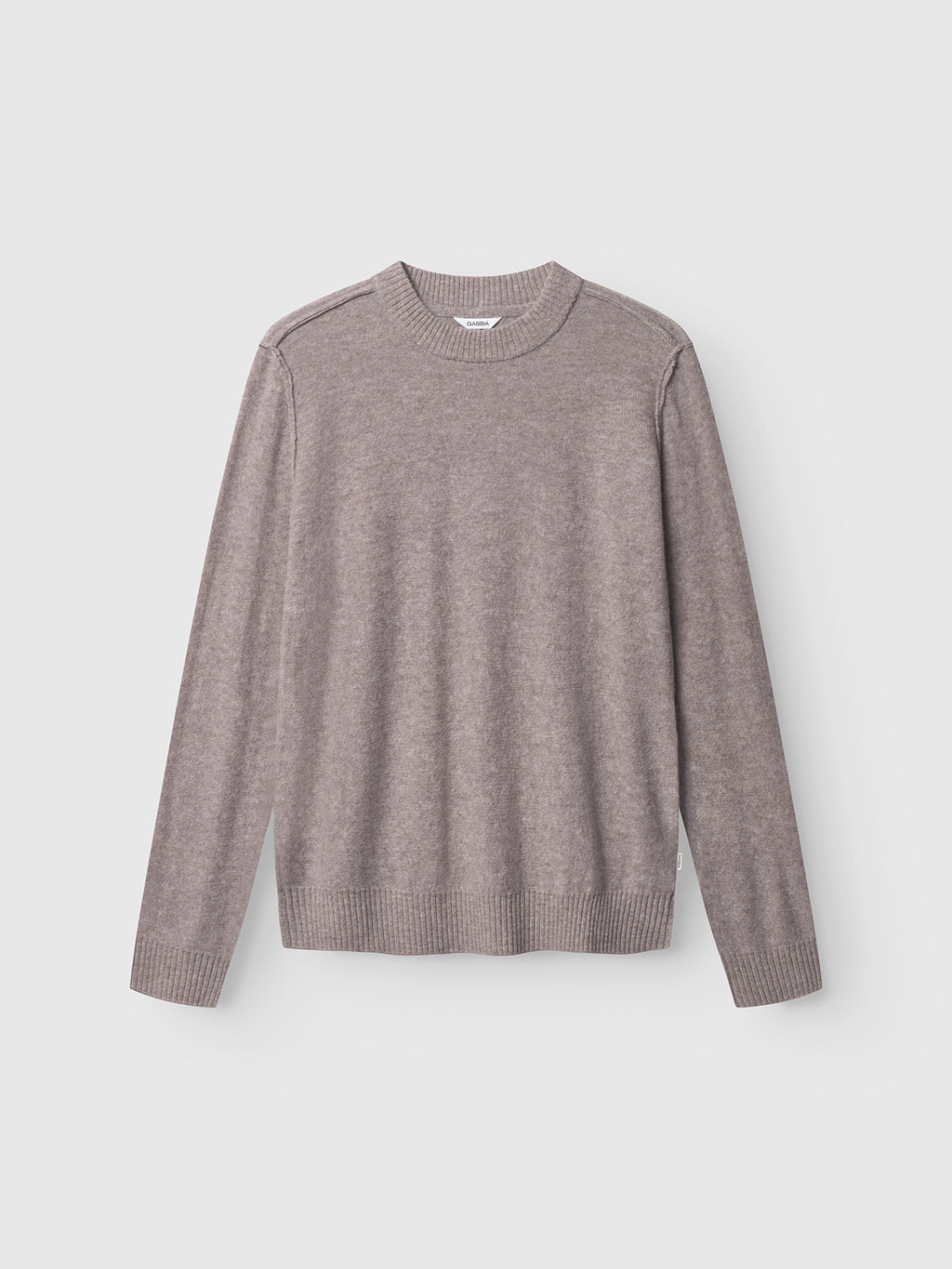 The Gabba Tokota Aico LS in light brown is a long-sleeve Merino wool crew neck sweater shown against a white background, featuring minimalist design and ribbed cuffs, hem, and neckline for breathable all-day comfort.