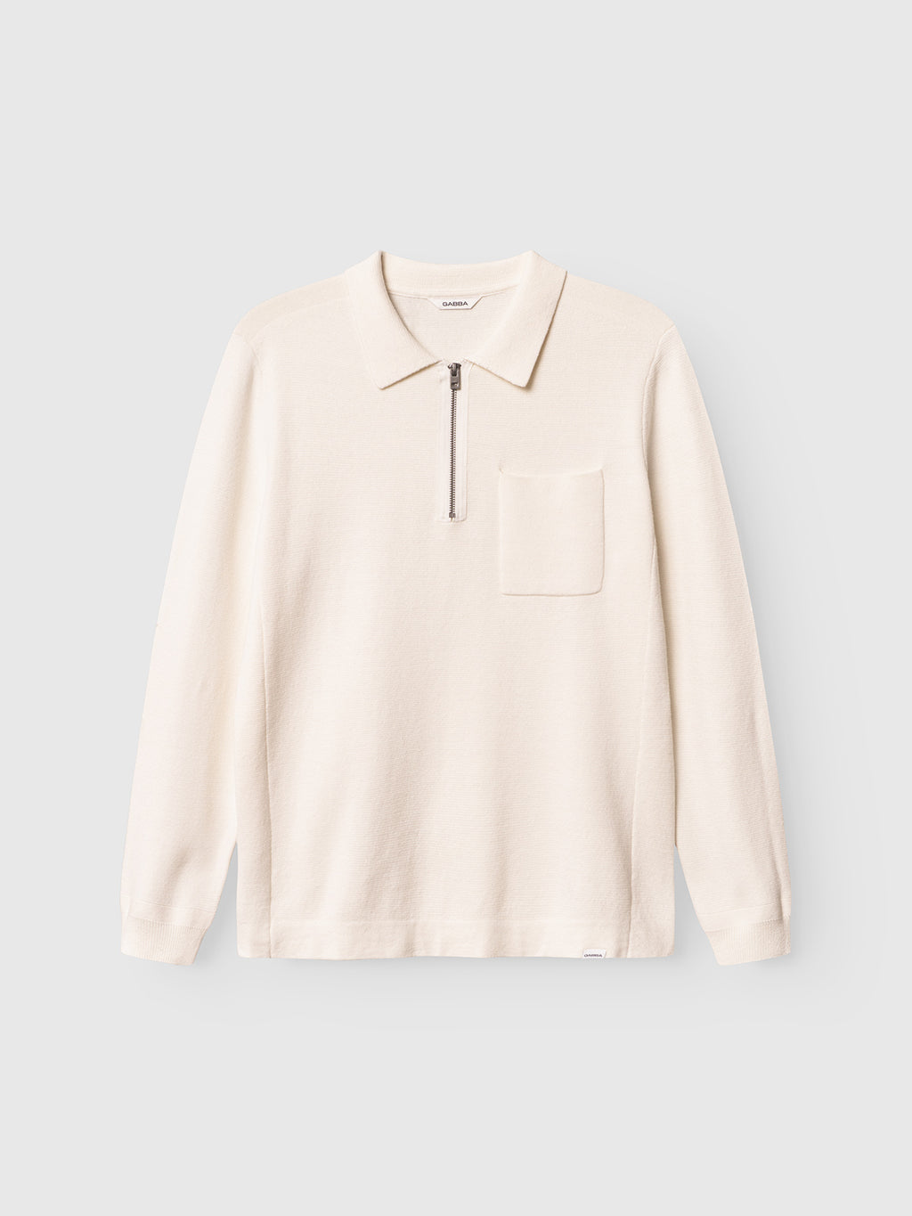 The Gabba Blanko New Zip LS in off-white is a long-sleeved men's sweater with a collar, half-zip knit closure, single chest pocket, and cotton-wool blend, shown laid flat on a light gray background.