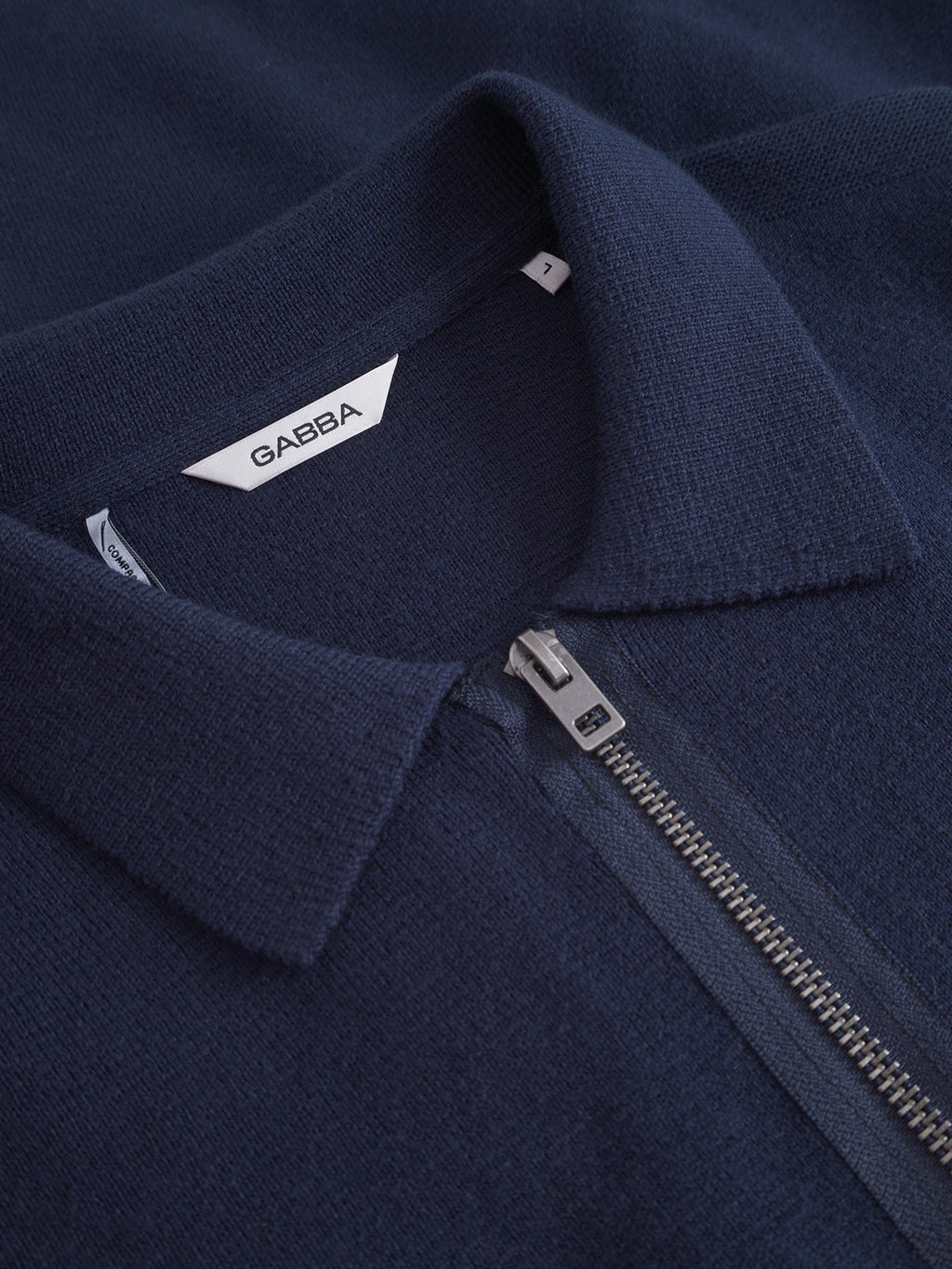 Close-up of the Gabba Blanko New Zip LS in navy—a soft, textured cotton-wool blend sweater featuring a half-zip silver zipper and a collared neckline. The label inside the collar displays the Gabba brand.
